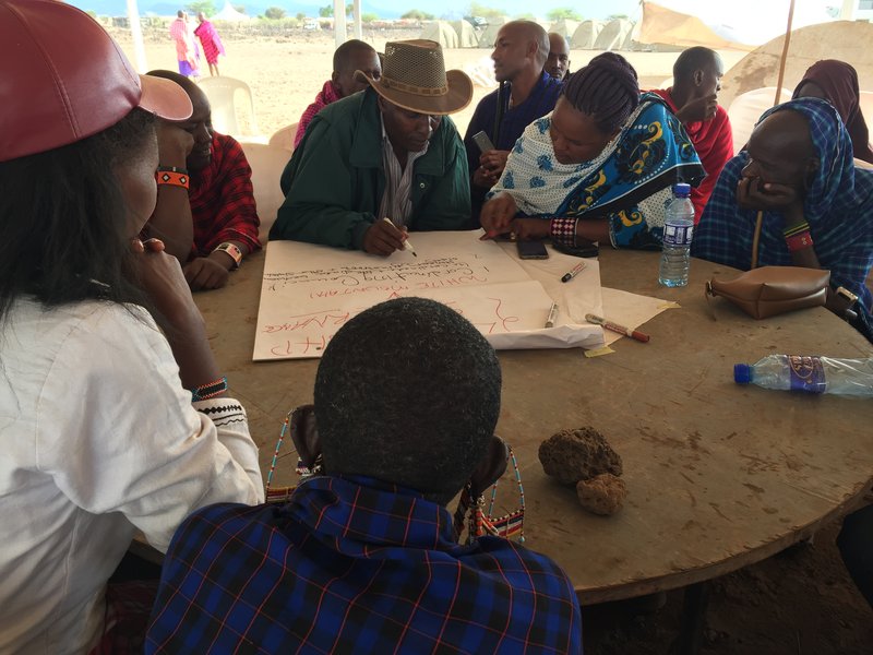 People standing around a table outside whilst making notes